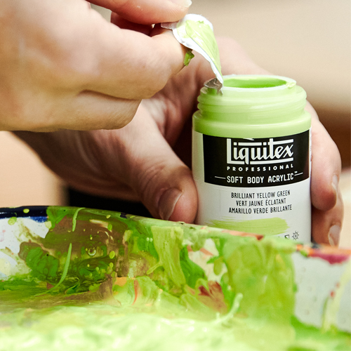 hand opening liquitex soft body paint bottle lid with green paint on palette in front